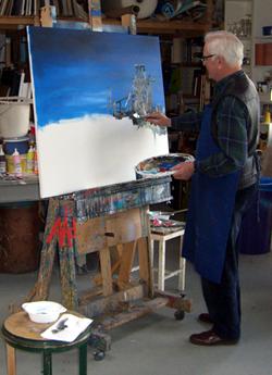 Mann steht vor einer Stafellei und malt.